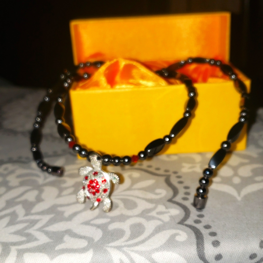 Silver and Red Turtle Charm on strand of Hematite beads with a magnetic clasp.